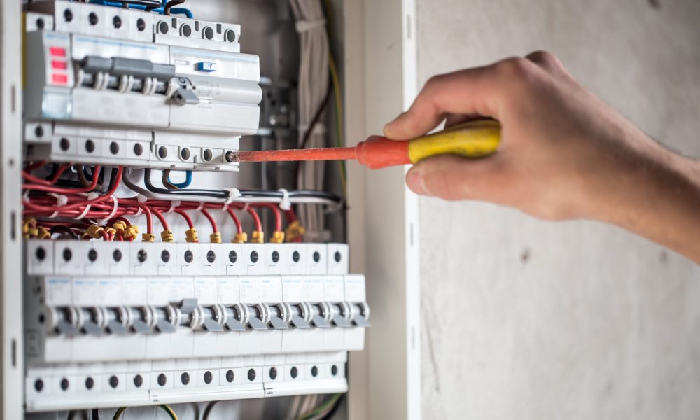 Man, an electrical technician working in a switchboard with fuses. Installation and connection of electrical equipment. Professional with tools in hand. concept of complex work, space for text. SSUCv3H4sIAAAAAAAEAI1Ry27CMBC8V+o/RD4TiZBAEv6gh0q9ox4264VYGBv50Qoh/r12jCufqt68M+vZnZ3760tVsQmsQLav7rEKtZDSW2fACa0CvF49cUOKkykR4sJpI0CW4AQOZwUXCqDyUkb4sZDMOnDeko3DnhCCo1PQSOCvRNrokOoqEwsZfgSKfZC+SmKrgrF+isy7sEhSgiLtLcv8Y/WH2Jvi0XJ08n/B9PjMvuFECm+LtcKyIUmQLB9SKzt/OzKX8gjgudCF/y+NIGNDWyhdjUChTsU37eYlj/wNtVfOxBVYtsGk1leYZAzjGDQp4zNYG9p5xotBGE6hL8Ucpd1i4KnKeMgslk27aYau23ZN0/f9sO4GlnPWeBa8tJiin0WgzK3ARdyAbVo8brEd6mbEXd0BbeqJdmO9hWHkww6xRwqHf/wA/SmPWrECAAA=